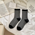 Soft wool blend socks with black and white stripes shown on a cozy white bedsheet - One Size / Black with Thin White Stripes