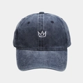 Detailed close-up of crown embroidery on vintage washed navy denim baseball cap - Navy Blue