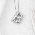 Macro shot of 3D puffed letter B silver pendant with shiny polished metal surface - Letter B Pendant