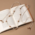 Close-up of bohemian woven waist rope with brown wooden beads on an open vintage book - Beige Rope Brown Wood Bead Woven (X451-8)