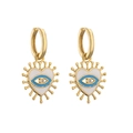 Macro-opname van gouden hart oorbellen met blauw emaille oog en zirkoon inlay - Blauw Wit Stralend