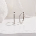 Macro shot of 925 sterling silver hoop earrings with sparkling zircon stones - 18mm / Silver