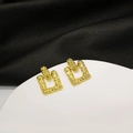 Macro view of gold-tone geometric rectangle earrings with lava texture on a sleek display - Gold Lava Texture Geometric Earrings