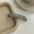 Gros plan sur une barrette en acétate avec motif marbré noir et blanc sur plateau - Points Noirs Et Blancs