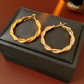 Macro shot of twisted gold hoop earrings with matte and polished interlaced textures - 24# Matte & Polished Twisted Style