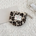 Flat lay of leopard print plush coin purse with beige zipper on soft white rug - Plush Beige Leopard Print