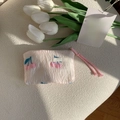 Detalle de bordado de cereza rosa y diseño acolchado en un neceser portátil - Cereza