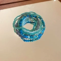 Detail of bohemian multilayer bead bracelets with blue and grey stones on a golden mirror - Blue (7-Piece Set)