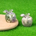 Natural crystal apple pendants with green and brown spots on wooden spoon background - Auspicious Jade