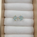 Four-claw sterling silver studs featuring light blue raw natural stone in gold finish - Aquamarine