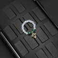 Detailed macro view of elastic beaded ring with green beads and gold diamond-shaped pendant - Green Bead Rhinestone Style (F-R584)