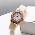 Makroaufnahme einer roségoldenen Tonneau-Uhr mit Diamantlünette und weißem Armband - Hellgelb