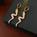 Detail of gold snake earrings with sparkling cubic zirconia on a black jewelry box - Snake Hoop Earrings - Gold (Real Gold Plated)