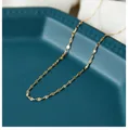 Detailed view of a gold-plated stainless steel lip chain on a blue ceramic tray - 45 cm / Lip Chain Fine (Gold)