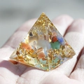 Miniature resin pyramid featuring colorful crystals and gold foil flakes in hand - Colored Agate