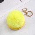 Close-up of bright yellow fluffy faux fur pom pom keychain with gold hardware detail - Yellow With Fur Ball