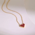 Macro detail of a red heart pendant with gold beaded edges on a titanium steel necklace - Gold Red Heart