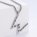 Macro shot of liquid metal style letter W pendant on box chain over white stone - Letter W (Pendant Only)
