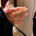 Elegante goldene Stern-Quasten-Ohrringe für Damen in professioneller Modellaufnahme - Gold