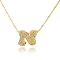 Macro shot of gold pendant letter N with micro-pave crystals on a thin box chain - Letter N