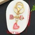 Detail view of pink glitter heart and envelope charms with XOXO text on a golden keychain - Pink Glitter Heart Envelope Style (ER1282)