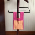 Pink and orange knit mini tote bag hanging on a wooden hanger with clear texture details - Patchwork Pink Orange