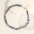 Detailed shot of irregular blue stone necklace with golden cube beads and metal clasp - Lapis Lazuli Color (NE2134-E)