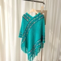 Teal knitted poncho featuring colorful geometric patterns and decorative hem tassels - Diamond Peacock Blue