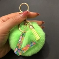 Detail of lime green pom pom and resin letter V keychain with heart sequins and tassel - Letter V