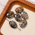 Detailed view of six oval spotted beige natural stone beads and metal pin on wood - Beige Black Spotted Texture Oval Style (12号)