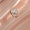 Dettaglio di un anello a fiore in argento con pavé di zirconi su raso rosa morbido - Anello con Fiore Rotante Argento (J0250)