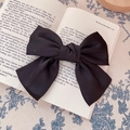 Elegant oversized black satin bow hair clip with vintage matte texture on book background - Hair Bow / Black