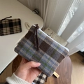 Makroaufnahme der Plaid-Tweed-Stoffstruktur und des gewebten Markenlabels - Blau und Kaffee Großes Karo