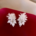 Detailed view of silver fireworks earrings with white pearls on a red velvet background - 36# Silver Needle - Silver - Fireworks