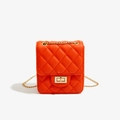 Close-up of orange quilted PU leather crossbody bag with gold chain strap and square lock - Orange
