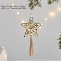 Stella di Natale dorata con nappe di seta appesa a un ramo di pino verde - H2023 Ornamento a Stella