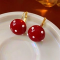 Detalle de pendientes de lunares rojos con ganchos dorados en una bandeja de cerámica - Rojo Dorado Con Lunares (Bañado En Oro Real)