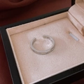 Detail of silver star ring with zircon inlay on beige velvet jewelry box cushion - Star Open Brushed Style / Silver