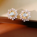Macro shot of sunburst champagne square cut earrings with crystal halo on silk - Gold Champagne