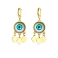 Detail von vergoldeten Evil Eye Ohrringen mit herzförmigen Anhängern auf weißem Hintergrund - Blauer Böser Blick