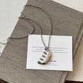Detailed macro shot of a silver comb-shaped pendant on a minimalist sweater chain necklace - Silver-Metal Chain Version