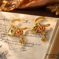 Detail of vintage gold hoop earrings with crown key and lock charms with enamel work - Lock and Crown Key Earrings (2-26258A-11000)