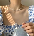 Collana a due strati di perle bianche intrecciate indossata sul collo femminile - Catena clavicola in perle intrecciate a doppio strato
