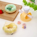 Gelbe und weiße Donut-Form Set auf Holzbrett mit künstlichen Donut-Modellen - Gelber runder Donut
