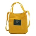 Minimalist yellow canvas bucket bag with adjustable shoulder strap and woven handles - Yellow