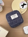 Detail of navy blue quilted heart pattern and woven label on a fabric pouch - Blue