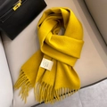 Yellow 100% Australian wool scarf with tassel detail displayed on a cozy beige sofa - Mustard Yellow