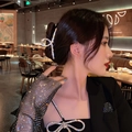 Sparkling rhinestone metal claw clip worn by a model in elegant banquet setting - Cross Rhinestone Claw Clip (82#)