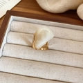 Détail macro d'une bague dorée minimaliste sertie d'une grande pierre en résine laiteuse - Bague (Blanc)