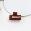 Detail shot of a brown rectangular hollow hair claw clip with a glossy acetate finish - Jelly Mini Claw - Square Deep Orange